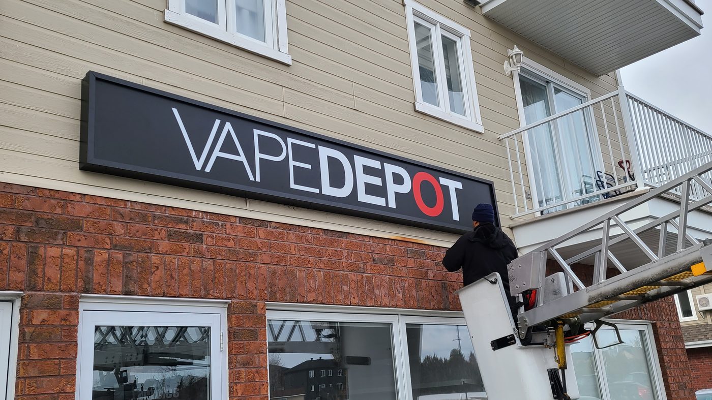 Installation d'un boîtier lumineux sur la façade d'un commerce
